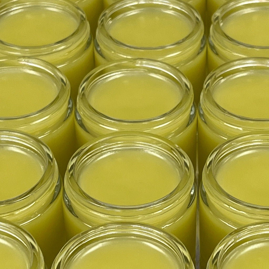Top view of open jars of belly & vaginal balm